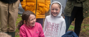 Two children laughing together during a bushcraft session at Longwood