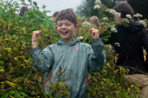 Children collecting bilberries in the nature reserve, gathering them for a bushcraft session
